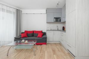 sala de estar con sofá negro y mesa de cristal en Apartamenty Horyzont SeaView by Rent like home, en Międzyzdroje
