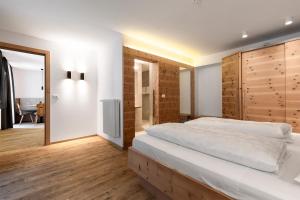 1 dormitorio con 1 cama grande y espejo en Zur Brücke in Mittewald - Your home in heart of South Tyrol, with Brixencard and free parking, ideal starting point for unforgettable excursions and outdoor adventures, en Fortezza