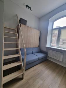 sala de estar con sofá azul y escalera en Central Vilnius studio - by Prime Rentals en Vilna
