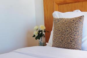 a vase of flowers sitting on a bed with a pillow at Majliss Hotel Downtown in Rabat