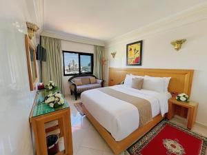 a hotel room with a large bed and a chair at Majliss Hotel Downtown in Rabat +37 photos