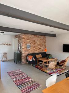 a living room with a couch and a brick wall at Charming holiday apartment - Beate in Ebeltoft