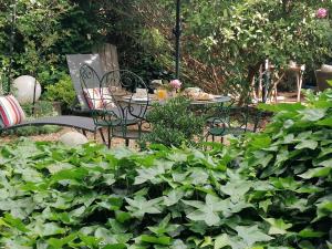 einen Tisch und Stühle in einem Garten mit Pflanzen in der Unterkunft Zoralie in Agde