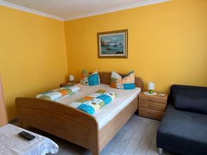 a bedroom with a bed with yellow walls and a couch at Pensione Italia in Alf