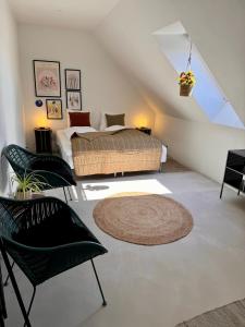 1 dormitorio con 1 cama y 2 sillas negras en Ellens Have, lejlighed Beate en Ebeltoft