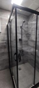 a shower with a glass door in a bathroom at YOUR HOUSE Apart Otel in Karaköprü Köyü