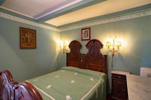 1 dormitorio con 1 cama y 2 luces en la pared en La villa nel bosco, en Strona