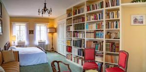 1 dormitorio con estanterías llenas de libros en La villa nel bosco, en Strona