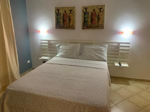 a bedroom with a bed with two pictures on the wall at Apartamento Antunes in Santa Maria