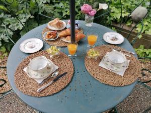 Zoralie في آجد: طاولة زرقاء مع أطباق من الطعام وكؤوس من عصير البرتقال