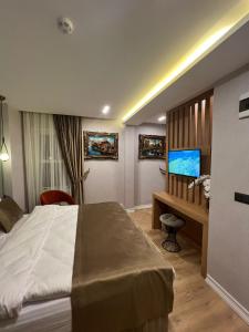a bedroom with a bed and a desk and a tv at The Aramis Galata Hotel in Istanbul
