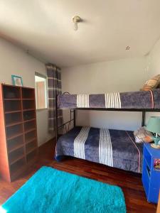 Habitación con 2 literas y alfombra azul. en Casa Campo Familiar, en Calana