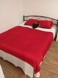 a bedroom with a red bed with two red pillows at Апартамент в Новобудові Стрийська Автовокзал in Lviv