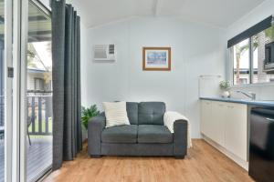 uma sala de estar com uma cadeira cinzenta numa cozinha em Tasman Holiday Parks - Fraser Coast em Hervey Bay