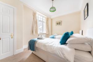 1 dormitorio con 1 cama con sábanas blancas y almohadas azules en 6 Meadowcroft House, en Bowness-on-Windermere