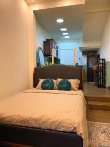 a bedroom with a bed with two green pillows on it at A Little Saigon in Ho Chi Minh City