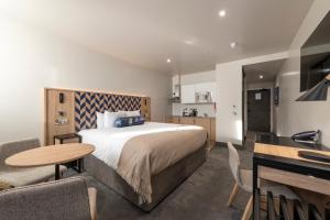 a hotel room with a bed and a table and chairs at Sandman Signature Glasgow Hotel in Glasgow
