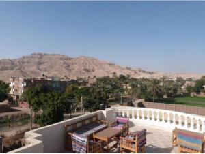 a balcony with tables and chairs with mountains in the background at Mountain View Apartments Hotel in Al Aqālitah
