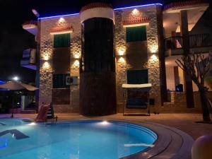 een zwembad voor een gebouw 's nachts bij Villa123 in El Alamein