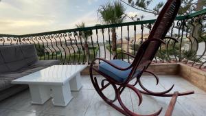 een schommelstoel bovenop een balkon bij Villa123 in El Alamein