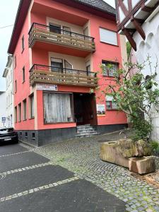 a red building with a balcony on the side of it at Pensione Italia in Alf