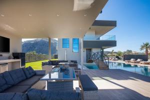 a living room with a couch and a table at Elinor Villa - Nature Retreat amidst Mountains & Lake by etouri in Chania