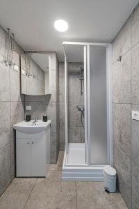 ein Bad mit einer Dusche, einem Waschbecken und einem WC in der Unterkunft Minimalist Studio Apartments by Hostlovers in Kaunas