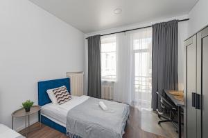 Schlafzimmer mit einem Bett, einem Schreibtisch und einem Fenster in der Unterkunft Minimalist Studio Apartments by Hostlovers in Kaunas