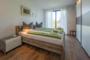 a bedroom with a large bed with a window at Fewo Konrad in Gaienhofen