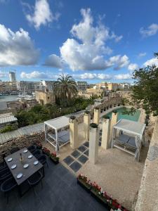 un patio con 2 mesas de picnic y una piscina en Villa Vera with private pool near Valletta, en Tal-Pietà