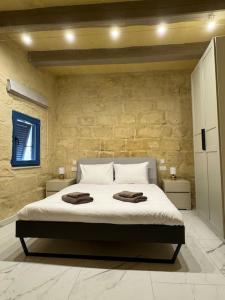 1 dormitorio con 1 cama con 2 toallas en Villa Vera with private pool near Valletta, en Tal-Pietà