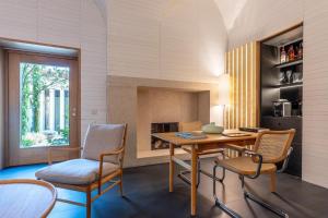 a dining room with a table and chairs and a fireplace at Atrio in Cáceres