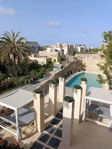 un balcón con 2 mesas y una piscina en Villa Vera with private pool near Valletta, en Tal-Pietà