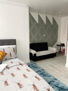 a bedroom with a bed and a couch at Stanton - Impeccable and stylish 2 bedroom in Dagenham