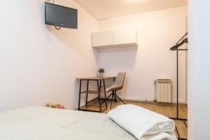 Cette chambre comprend un lit, une table et une télévision. dans l'établissement Bettatur Apartament Anfiteatre Romà, à Tarragone