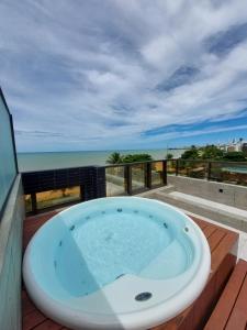 a jacuzzi tub on a balcony with the ocean at Arpoar Suítes by Slaviero Hotéis in João Pessoa