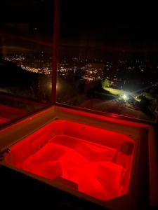 een rood bad in een kamer met een raam bij CABAÑAS CRISTALES DE BELLA VISTA in Paipa