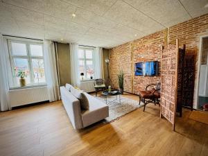 een woonkamer met een bank en een bakstenen muur bij Hotel Gammel Havn in Fredericia