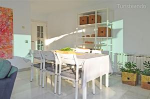 a dining room with a white table and chairs at Apartamento de lujo Aquarela - piscina climatizada y parking in San Vicente de la Barquera +40 photos