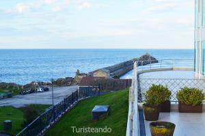 a view of the ocean from the balcony of a building at Apartamento de lujo Aquarela - piscina climatizada y parking in San Vicente de la Barquera