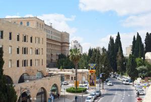 una concurrida calle de la ciudad con coches aparcados en la carretera en King David Luxury Apartments en Jerusalén