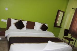 uma cama grande num quarto com paredes verdes em Hotel Prithvi Haridwar - Excellent Stay with Family, Parking Facilities em Haridwār