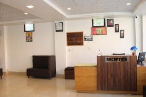 uma sala de espera com uma recepção e uma cadeira em Hotel Prithvi Haridwar - Excellent Stay with Family, Parking Facilities em Haridwar