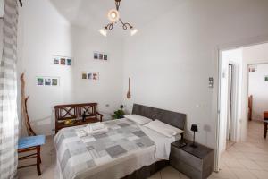 ein weißes Schlafzimmer mit einem Bett und einem Kronleuchter in der Unterkunft Dimora Sanna Nature & Sea View in Polignano a Mare