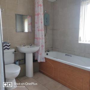 La salle de bains est pourvue d'un lavabo, de toilettes et d'une baignoire. dans l'établissement Nice 2 Bedroom house near City hospital, à Nottingham