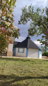 een blauw-wit huis met een zwart dak bij Trullo Iris in Cisternino