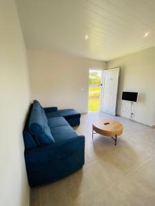uma sala de estar com um sofá azul e uma mesa em Villa cosy Blue Lagon em Rivière-Salée