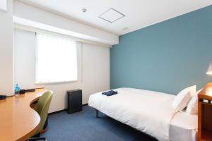 a bedroom with a bed and a desk and a table at Sun Days Kagoshima in Kagoshima +72 photos