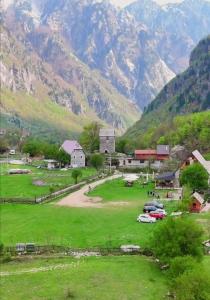 ein kleines Dorf mit Bergen im Hintergrund in der Unterkunft Petriti theth in Theth