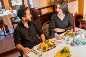 un hombre y una mujer sentados en una mesa en un restaurante en Hotel & Restaurant Hanse Kogge, en Ostseebad Koserow